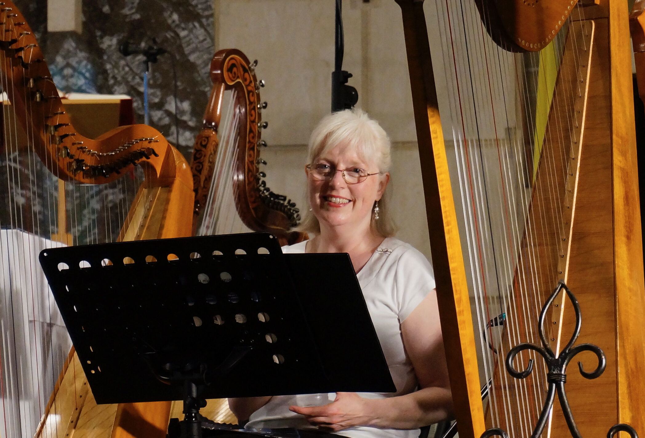 Helen at music stand surrounded by Celtic harps.